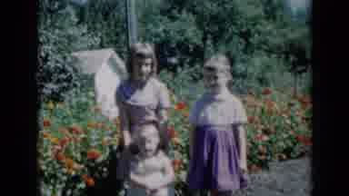 Missouri USA (1961): Three Siblings Standing By A Flower Garden Posing For A