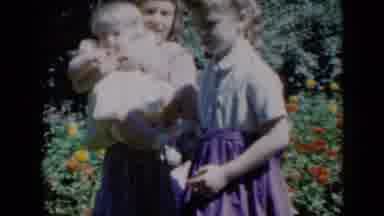 Missouri USA (1961): Girls Wearing White And Purple Dresses Walk Past Red And