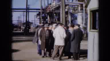 Missouri USA (1961): Group Of Men Stand Beside Grey Shack At Factory On A Bright