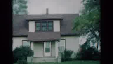 Missouri USA-1961: Two Story House Followed By Brown And White Dairy Cow Chewing