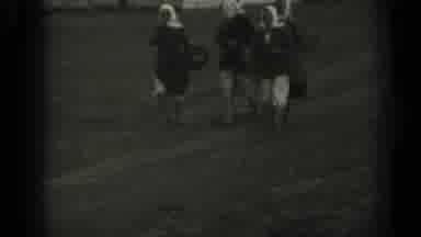 Missouri USA (1961): Woman In Dresses With White Hoods Carrying Bags And Walking