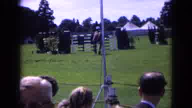 England (1963): An Audience Watches A Horse Jumping Event As A Man With White Hair