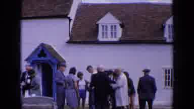 England (1963): People Standing Outside Church House On Grass Dressed Up Near