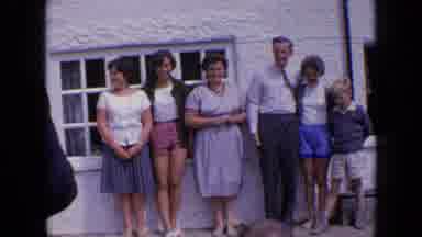 England (1963): Family Taking Pictures By Building Near River With Old Bridge