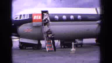 England (1963): Passengers Need Assistance As They Depart Airplane Which Is Being