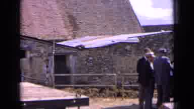 France (1963): Man Wearing Black Suit Walks To Group If Of People Standing Next To