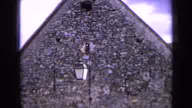 France (1963): Brick Building And A Man With A Yellow Cane With Two Spotted Dogs