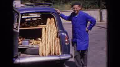 France (1963): A Man Standing Near His Car With The Trunk Open With A Lot Of Bread