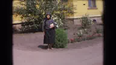 France (1963): Elderly Lady Escorted Away From Home By Two Men Then Poses In