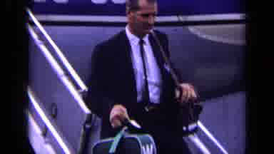 London England (1963): Person With Luggage Walking Down An Airplane Towards Person