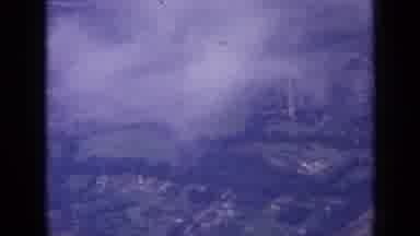 London England (1963): Aerial View Of A Small Town With Many Trees Cars And Houses
