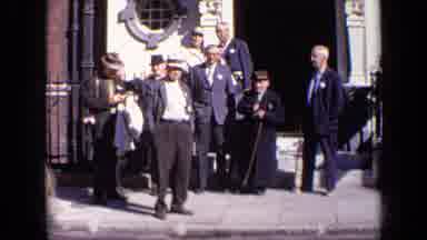 London England (1963): Men Standing Outside A Beautiful Building Watching Others