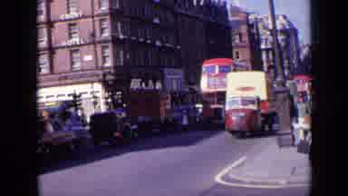 London England (1963): People Driving Bus Car Heavy Traffic Road Near Buildings