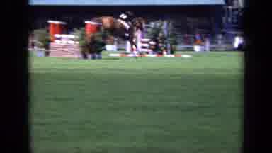 London England (1963): Horse And Rider Jumping Obstacles In A Field