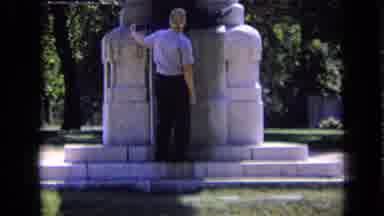 Russia (1963): Man Walking Examining Base Of Stone Memorial With Statues Of Person
