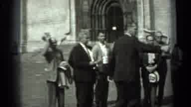 Russia (1963): Group Of Men Pose In A Courtyard In Front Of A Large Building For A