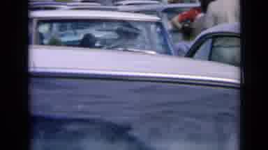 Kansas USA (1964): People Leaning Against Cars During Traffic Jam On A Clear Day