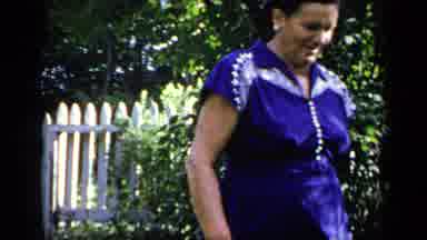 New York (1948): Woman Walking Through Garden With Plants And Flowers In Sunny Day
