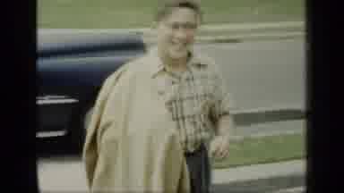 New York (1948): A Person Walking With A Blanket Draped Over Their Arm In Front Of