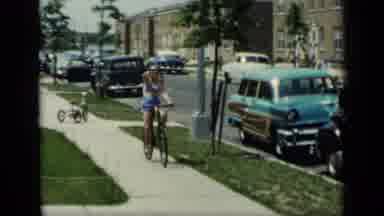 New York (1948): Girl Wearing Blue Shorts Rides Bicycle Waving To Camera On A