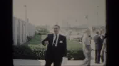 New York (1948): Man Wearing Black Suit Waves To Camera Man On A Sunny Day