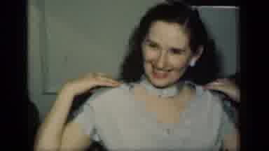New York (1949): Woman Models Blue And Brown Dress While Sitting On Brown Sofa