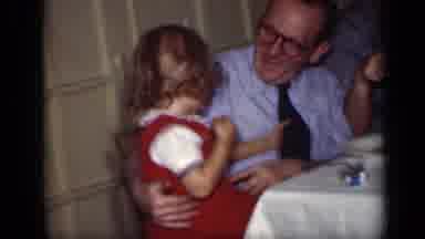 New York (1949): A Man Sitting At A Table With A Child On His Lap Points In The