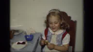 New York (1949): Girl Wearing Blue Dress Sits In Brown Chair Eating Candy