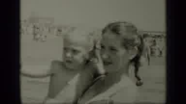 New York (1949): Girl Holding Small Child In The Water While Lots Of People Swim