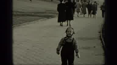 New York (1949): A Small Child Wearing Winter Clothes Laughs As They Walk Towards