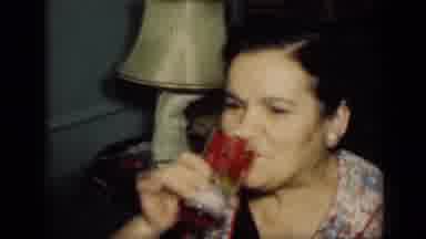 New York (1949): Woman Wearing Black Dress Drinks From Red Cup While Woman Wearing