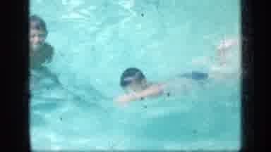 New York (1957): Boy Wearing Blue Shorts Swims Then Stands In Pool On A Bright