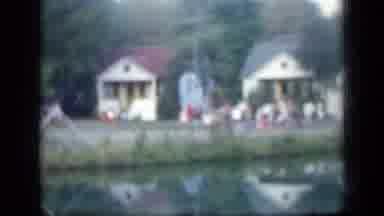 New York (1957): People Gathering In Front Of White Building Near Lake On A Clear