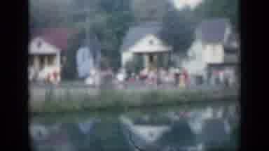 New York (1957): Small Crowd Gathers In Front Of White Building Near Water On A