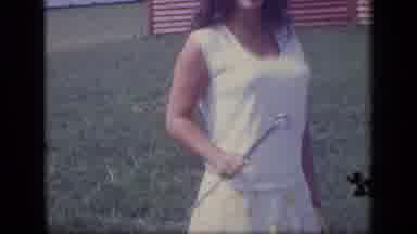 New Jersey (1970): A Woman In A Skirt Is Waving While A Child Plays