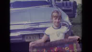 New Jersey (1970): A Young Girl Stands Behind A Blue Car Holding A Piece Of Art