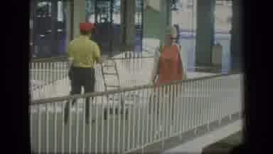 Puerto Rico (1970): Woman Wearing Orange Dress Runs Arm Along Brown Bridge Railing