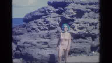 Puerto Rico (1970): Woman Walking Carefully Through The Water On A Rocky Beach In