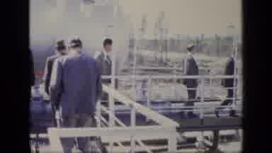 Moscow Russia (1971): Men Wearing Grey Suits Walk Towards White Shed On A Sunny
