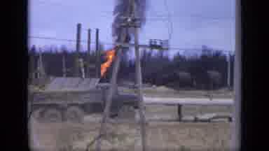 Moscow Russia (1971): Black Truck Drives By Small Grey Structure Spewing Fire On A