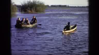 Moscow Russia (1971): Four People In One Canoe Paddle Alongside One Person In A