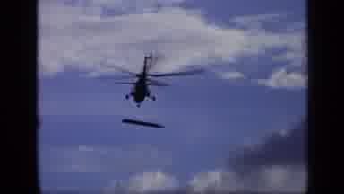 Moscow Russia (1971): A Helicopter Flying On A Blue Sky With A Bar Like Object