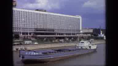 Moscow Russia (1971): A Barge Floats Down A River In Front Of A Roadway And Large