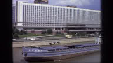 Moscow Russia (1971): Barge Traveling Down A Body Of Water With Large Building In