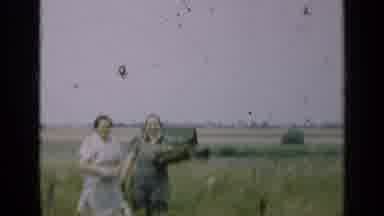 Illinois USA (1947): Two Women In Dresses Standing In A Grassy Field While The