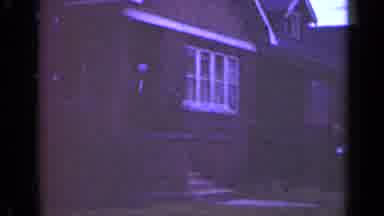Illinois USA (1947): People Wearing Black Coats Leave Brick House On A Clear