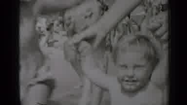 New York (1947): A Man Making Something For His Baby Several Kids Are Shown On His