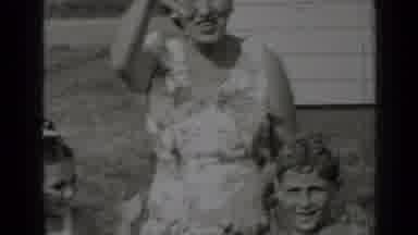 New York (1947): Woman Wearing White Dress And Kids Wave At Camera On A Sunny Day