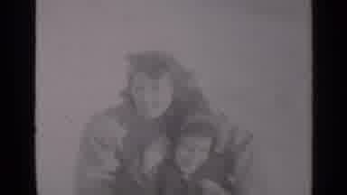 New York (1947): Woman Holding Child In Lap Waves At Camera In A Cloudy Winter Day
