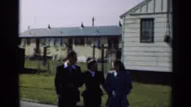 New York (1947): Three Well Dressed People Walk Toward Camera With A Green Lawn